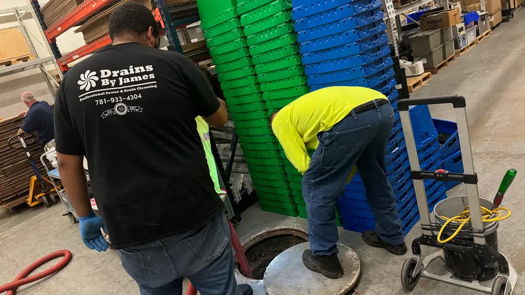 Technician working at a floor manhole in a warehouse