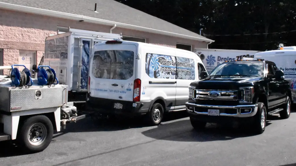Drains By James van, pickup and equipment trailer parked in the lot outside the shop